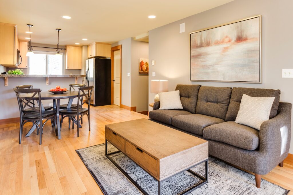 Sala de estar em estilo open space com um tapete e um sofá em destaque