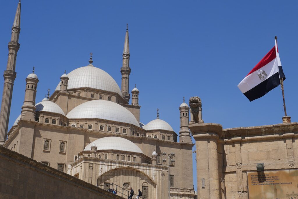 Foto mostrando uma mesquita com a bandeira do Egito em primeiro plano